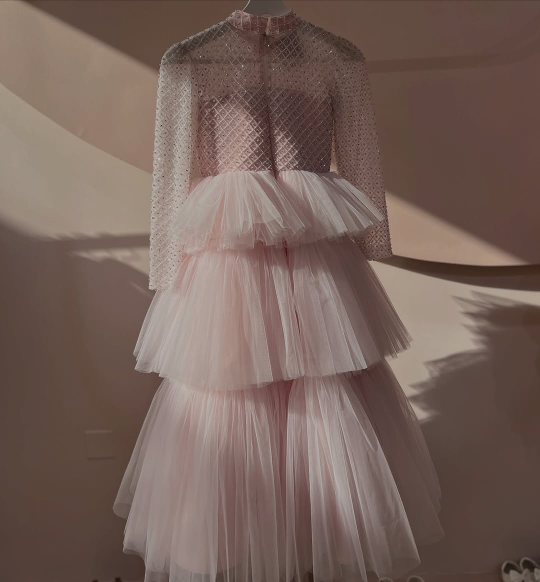 Delicate and elegant baby dress crafted in soft blush pink tones